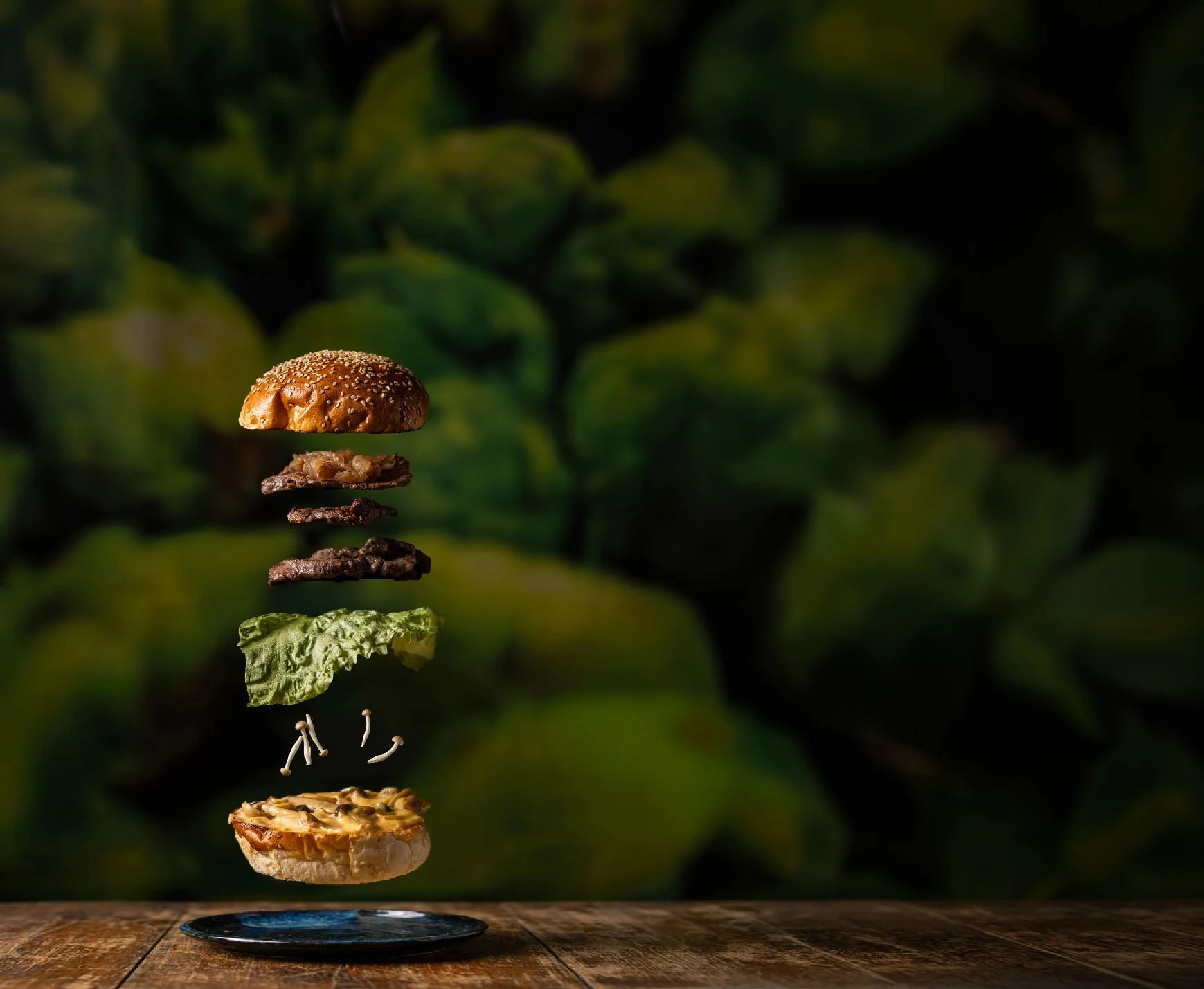 A dramatically lit burger with ingredients suspended above it